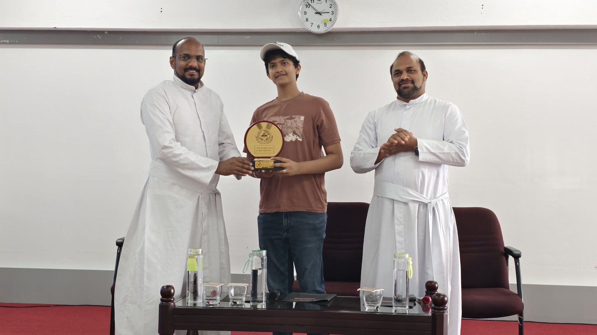 A student facilitator receiving a commemorative plaque