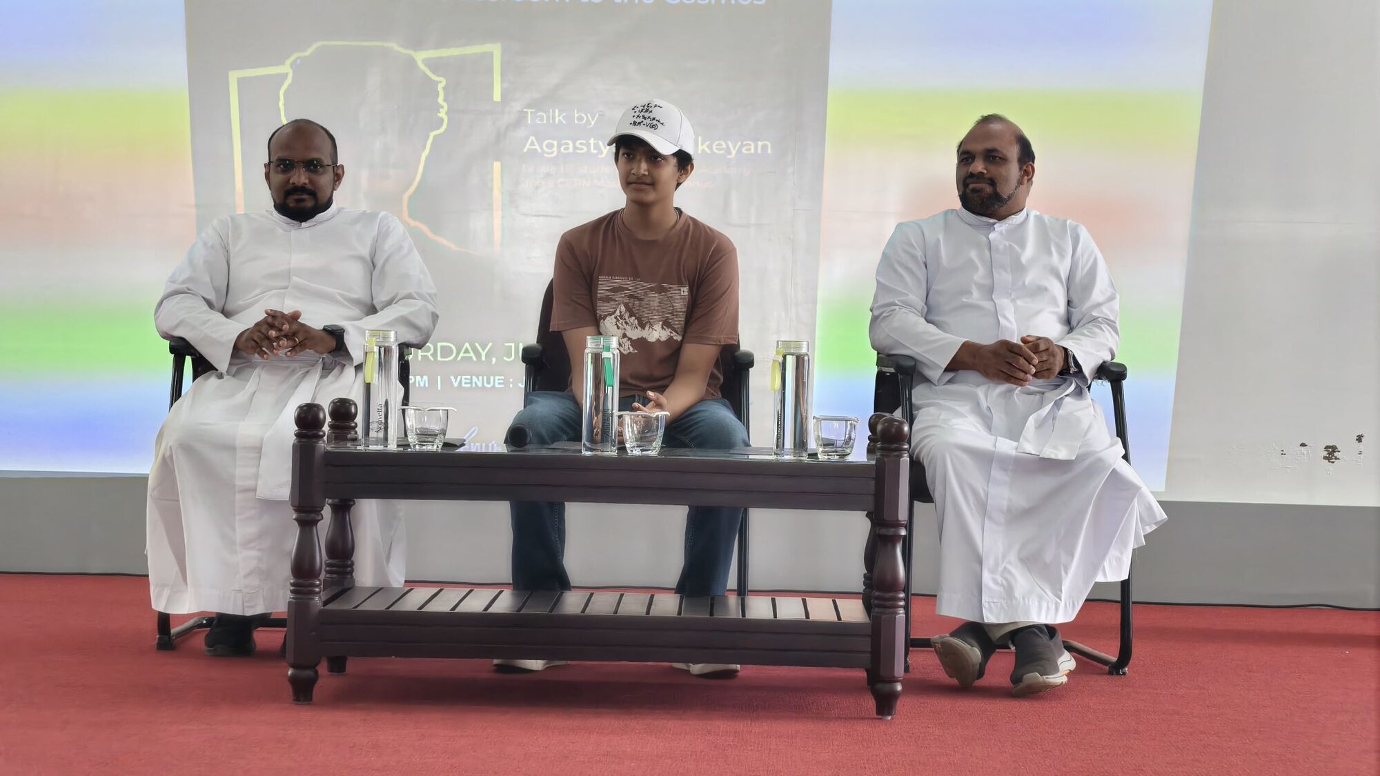 A student facilitator seated with school leaders during a presentation