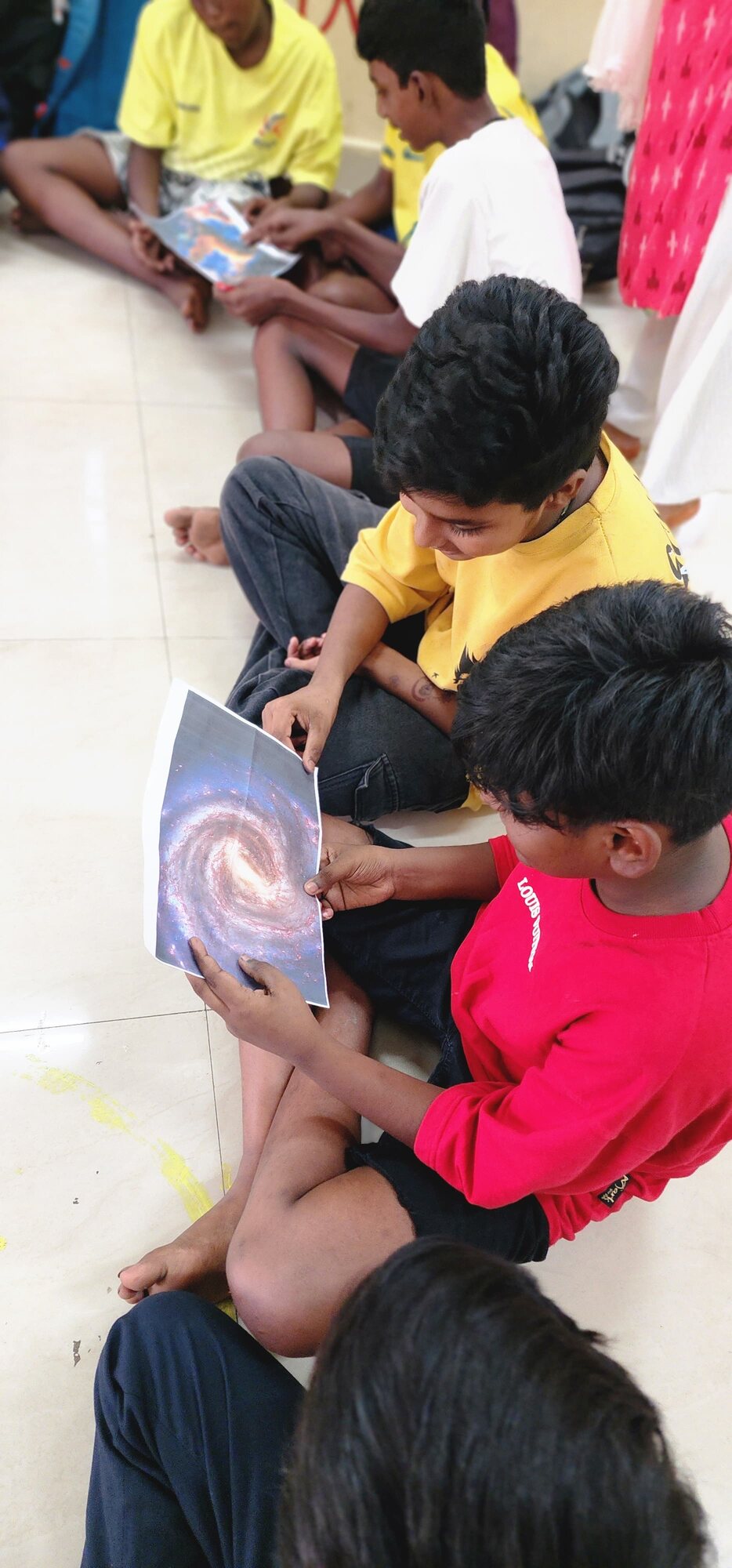 Students examining a printed image of a spiral galaxy