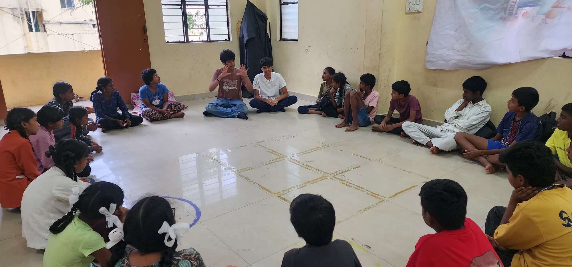 A facilitator and students talking across a floor activity