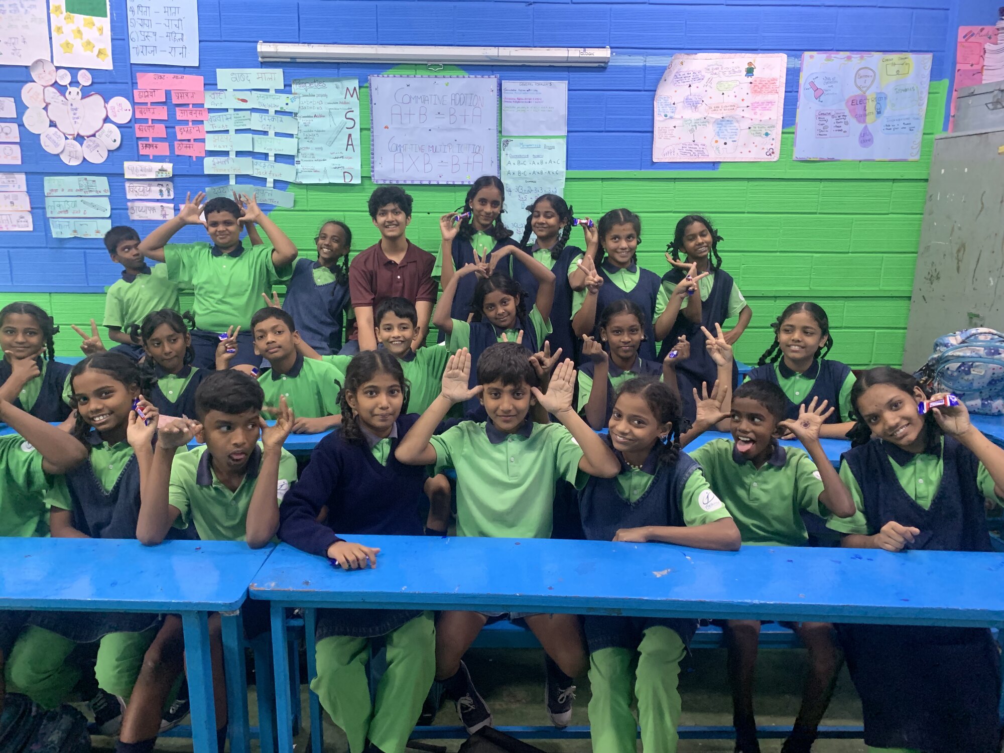 Students and WIEMO facilitators posing together in a classroom