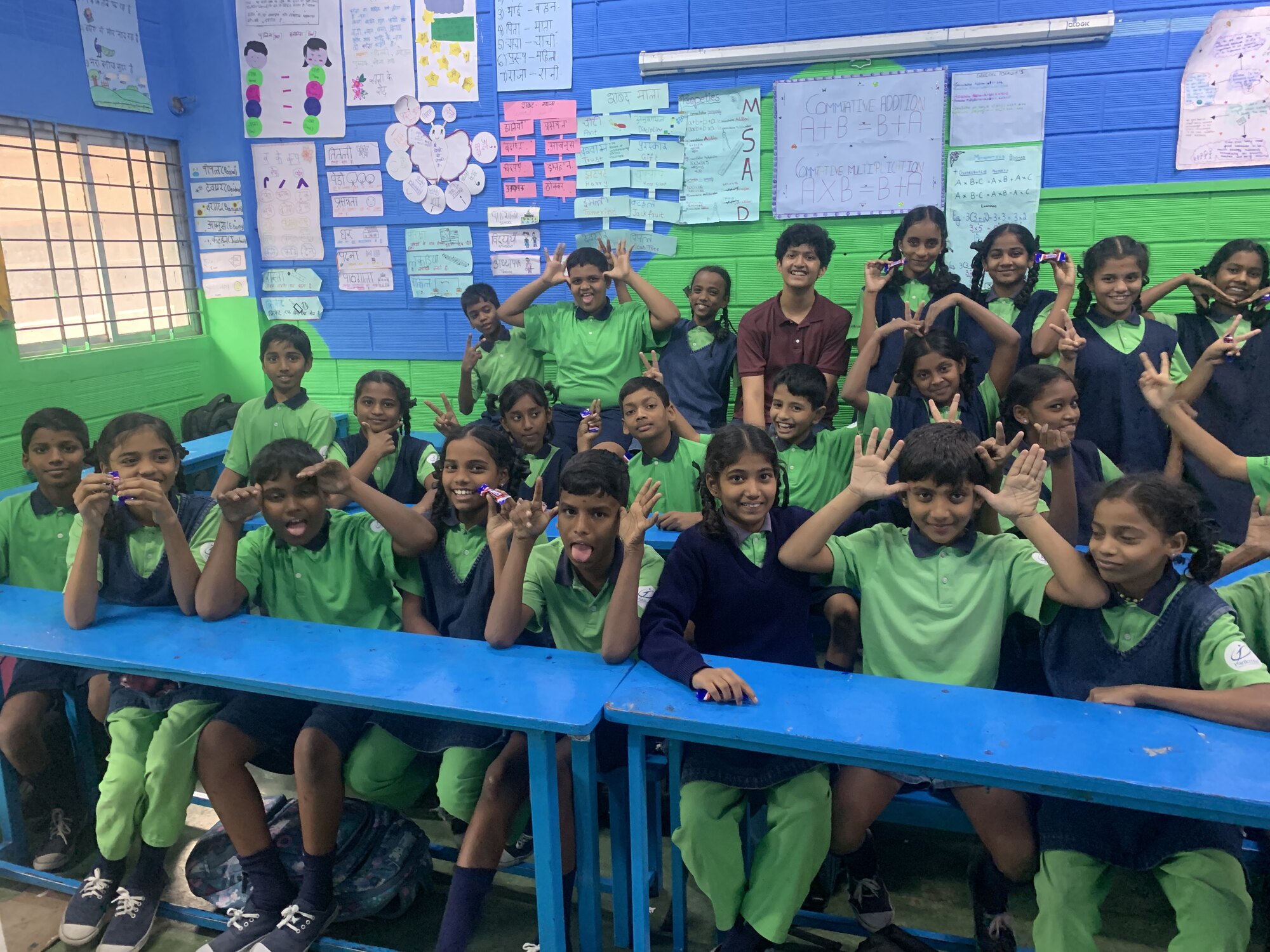 Students smiling and making playful poses with WIEMO facilitators